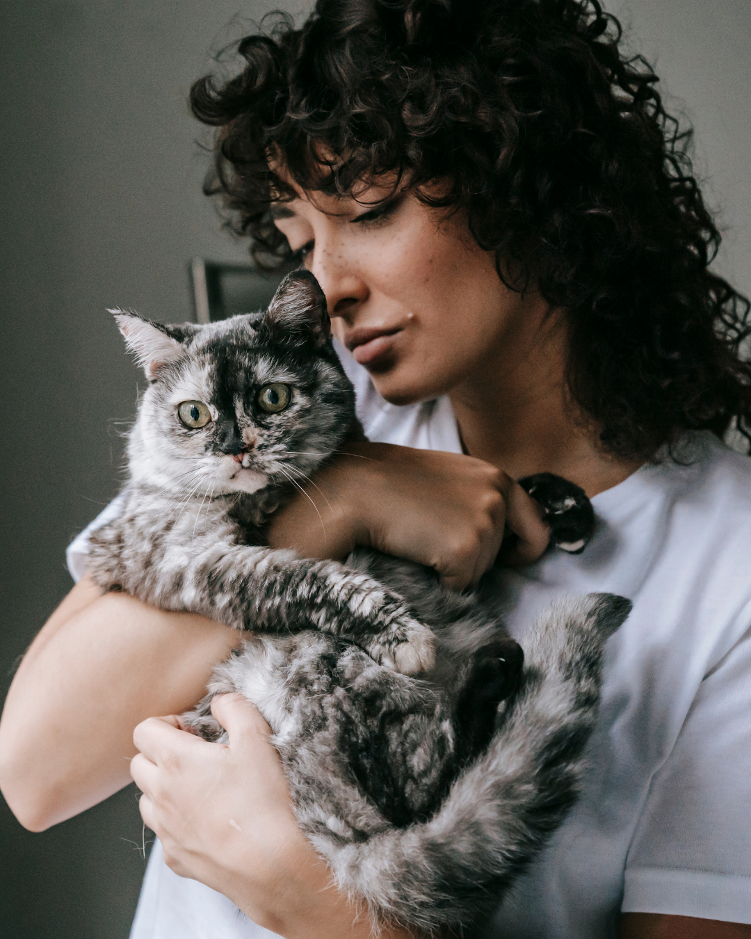 Young woman gently holding her cat close, a quiet moment of connection